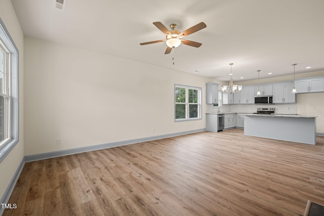 147 Harmony Trl, Broadway, NC 27505 - unfurnished living room with light wood-type flooring, a chandelier, ceiling fan, recessed lighting, and baseboards