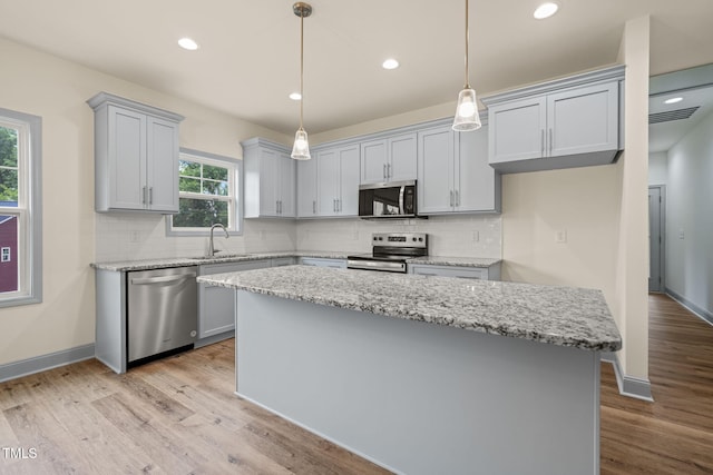 147 Harmony Trl, Broadway, NC 27505 - kitchen featuring appliances with stainless steel finishes, a sink, a kitchen island, light wood-style flooring, and recessed lighting