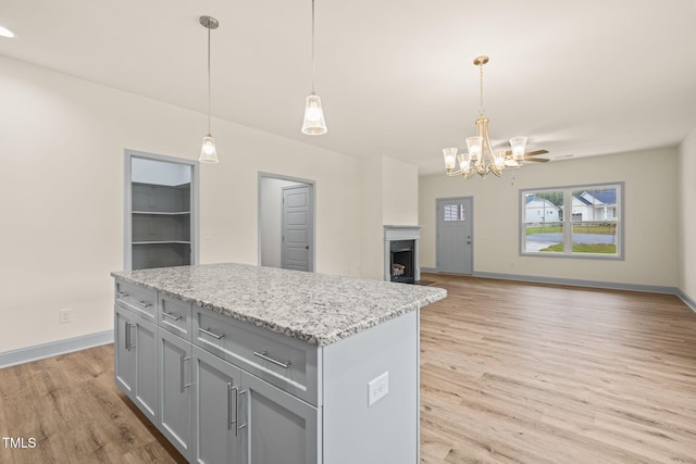 147 Harmony Trl, Broadway, NC 27505 - kitchen with gray cabinets, light wood-style floors, a chandelier, and baseboards