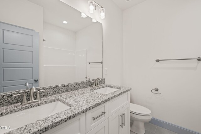 147 Harmony Trl, Broadway, NC 27505 - bathroom featuring tile patterned floors, double vanity, toilet, and baseboards