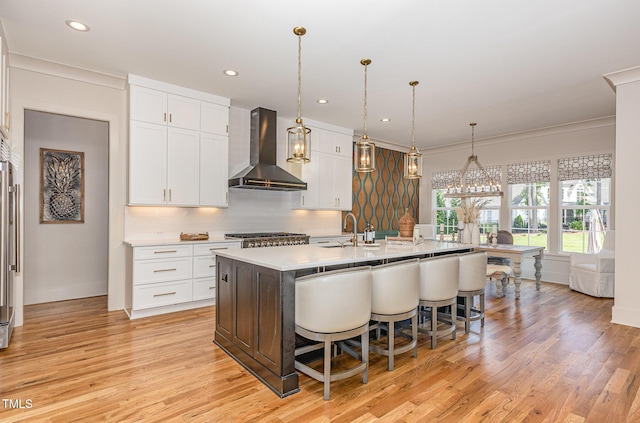 2328 Sanctuary Dr, Raleigh, NC 27606 - kitchen with wall chimney exhaust hood, a sink, white cabinets, tasteful backsplash, and a breakfast bar