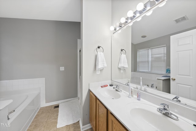 2910 Barrymore St Unit 100, Raleigh, NC 27603 - full bath with double vanity, a bath, baseboards, and tile patterned floors