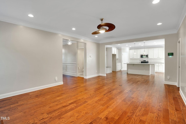 20 Sugarpine Trl, Clayton, NC 27520 - unfurnished living room with a ceiling fan, wood finished floors, recessed lighting, crown molding, and baseboards
