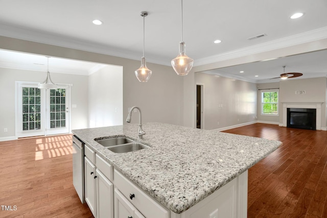 20 Sugarpine Trl, Clayton, NC 27520 - kitchen with a sink, an island with sink, a ceiling fan, light wood finished floors, and white cabinetry