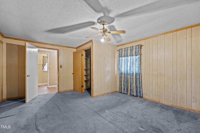 4038 Redwood Rd, Durham, NC 27704 - unfurnished bedroom featuring wood walls, crown molding, carpet flooring, baseboards, and a textured ceiling