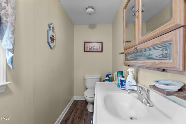 4038 Redwood Rd, Durham, NC 27704 - half bath with a sink, toilet, wood finished floors, and baseboards