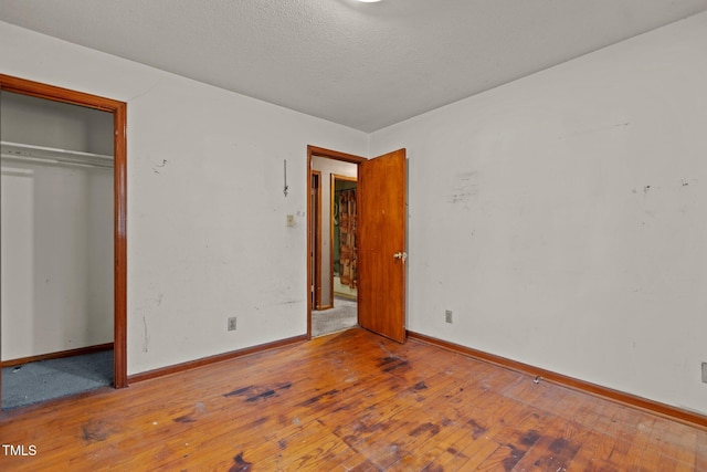 4038 Redwood Rd, Durham, NC 27704 - unfurnished bedroom with hardwood / wood-style floors, baseboards, a closet, and a textured ceiling
