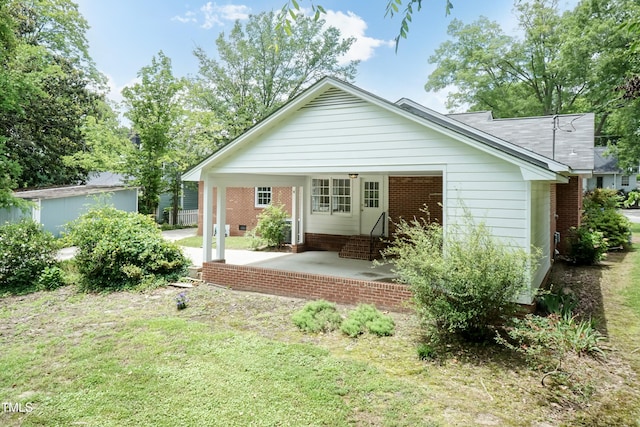 303 Spring St, Louisburg, NC 27549 - rear view of property with brick siding and a lawn