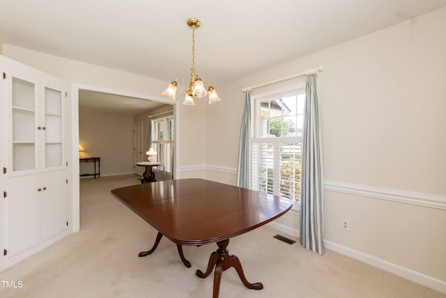 303 Spring St, Louisburg, NC 27549 - dining space featuring light colored carpet, a chandelier, and baseboards