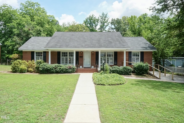 303 Spring St, Louisburg, NC 27549 - view of front facade with brick siding and a front yard