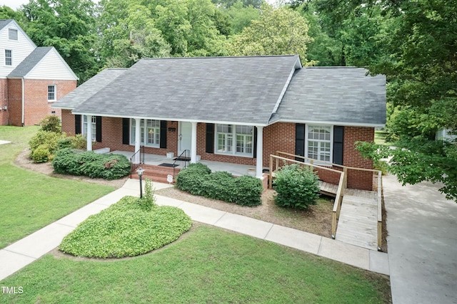 303 Spring St, Louisburg, NC 27549 - view of front of home featuring brick siding, a front lawn, roof with shingles, and covered porch