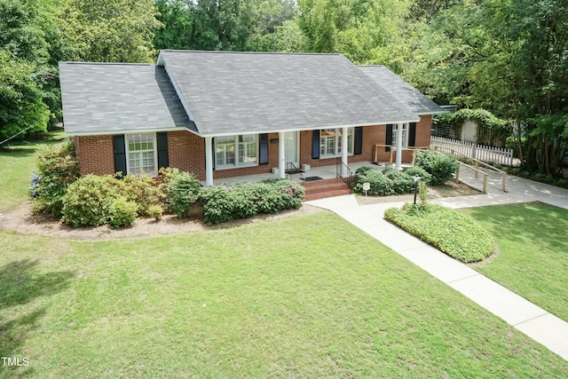 303 Spring St, Louisburg, NC 27549 - cape cod-style house with brick siding, covered porch, and a shingled roof