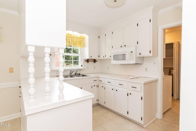 303 Spring St, Louisburg, NC 27549 - kitchen featuring a sink, white microwave, crown molding, white cabinets, and washing machine and dryer