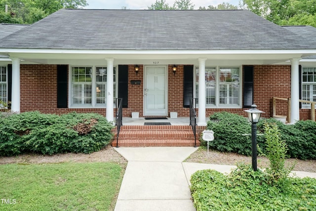 303 Spring St, Louisburg, NC 27549 - entrance to property with brick siding, a shingled roof, and a porch