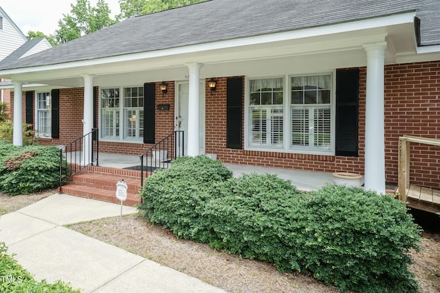 303 Spring St, Louisburg, NC 27549 - entrance to property featuring brick siding, covered porch, and roof with shingles