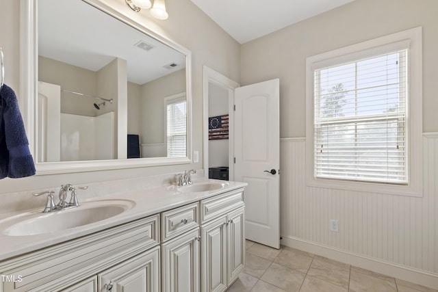 2661 Silver Bend Dr, Apex, NC 27539 - full bathroom with tile patterned flooring, double vanity, a wainscoted wall, a shower, and baseboards