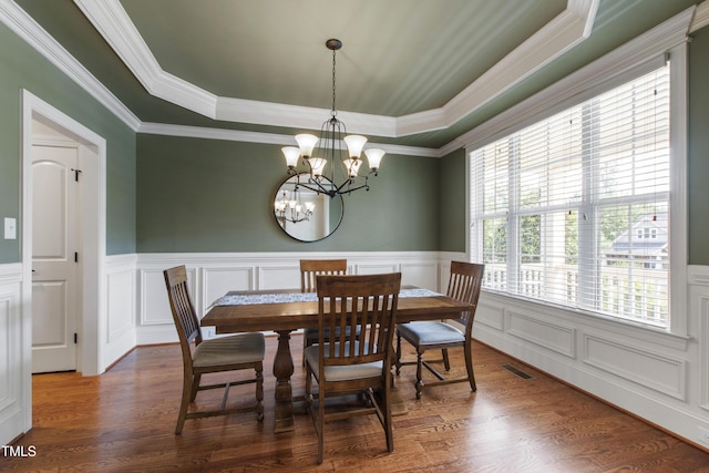 2661 Silver Bend Dr, Apex, NC 27539 - dining area featuring a tray ceiling, a chandelier, a decorative wall, a wainscoted wall, and wood finished floors
