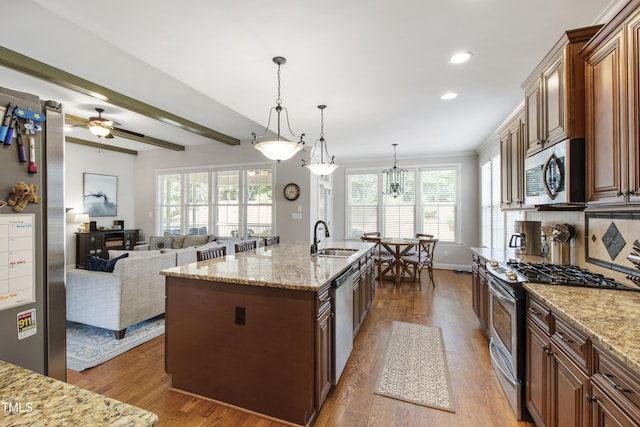 2661 Silver Bend Dr, Apex, NC 27539 - kitchen featuring stainless steel appliances, a sink, wood finished floors, light stone countertops, and recessed lighting