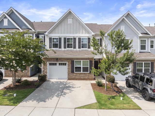 409 Rhamkatte Rd, Holly Springs, NC 27540 - view of front of house with board and batten siding, an attached garage, concrete driveway, a shingled roof, and stone siding