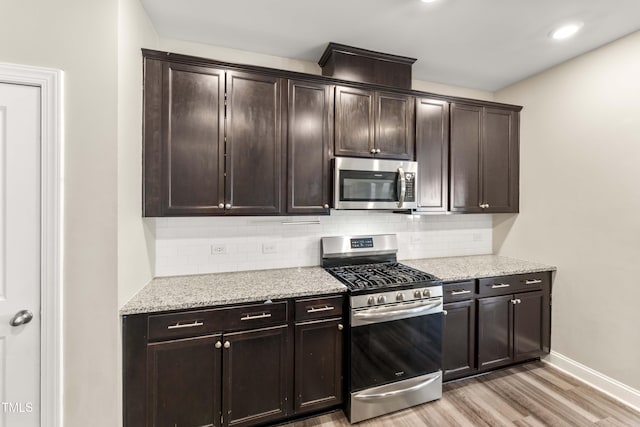 409 Rhamkatte Rd, Holly Springs, NC 27540 - kitchen featuring stainless steel appliances, light wood-style flooring, decorative backsplash, baseboards, and recessed lighting