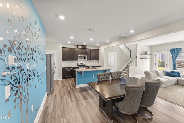 409 Rhamkatte Rd, Holly Springs, NC 27540 - dining space featuring light wood-style floors, stairway, recessed lighting, and baseboards