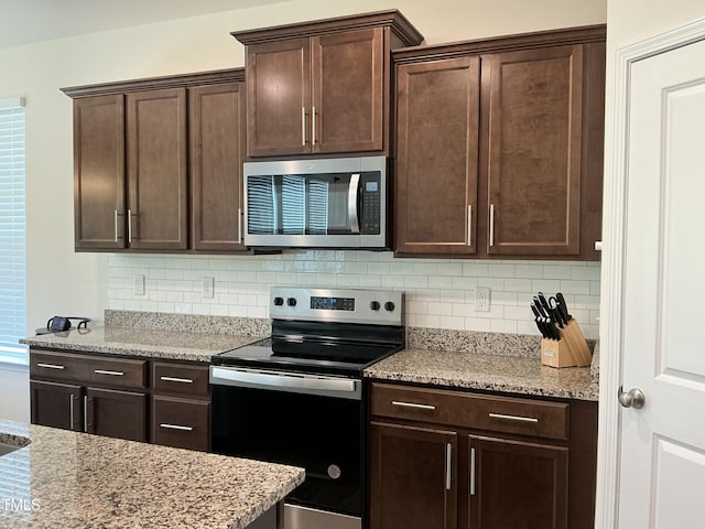 1116 Sidney Creek Dr Unit 1116, Zebulon, NC 27597 - kitchen featuring appliances with stainless steel finishes, dark brown cabinets, backsplash, and light stone counters