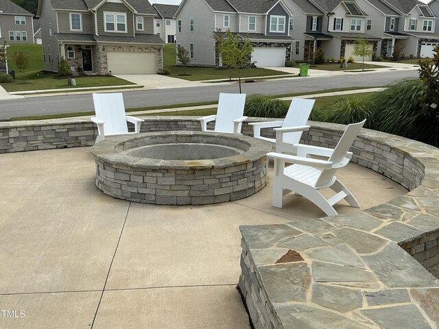 1116 Sidney Creek Dr Unit 1116, Zebulon, NC 27597 - view of patio featuring a residential view, a fire pit, and an attached garage