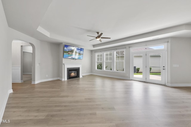537 Bramble Ln, Clayton, NC 27527 - unfurnished living room with ceiling fan, light wood finished floors, plenty of natural light, and a tray ceiling