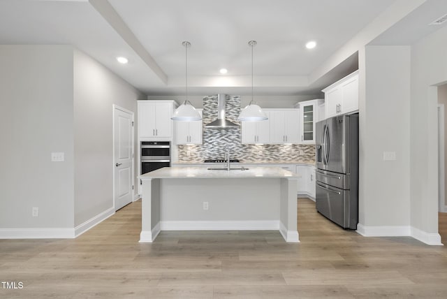 537 Bramble Ln, Clayton, NC 27527 - kitchen with appliances with stainless steel finishes, wall chimney range hood, light countertops, a tray ceiling, and backsplash