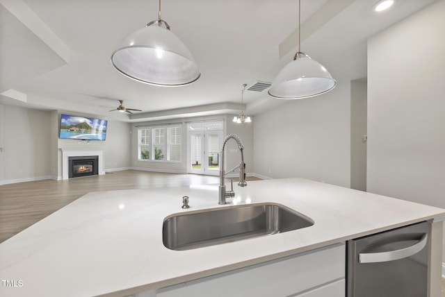 537 Bramble Ln, Clayton, NC 27527 - kitchen with dishwasher, open floor plan, light countertops, decorative light fixtures, and a glass covered fireplace