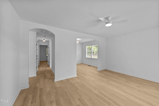 413 Top Greene Ln, Raleigh, NC 27601 - unfurnished room featuring arched walkways, light wood-type flooring, a ceiling fan, and baseboards