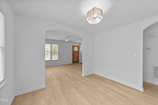 413 Top Greene Ln, Raleigh, NC 27601 - spare room featuring arched walkways, a ceiling fan, light wood-type flooring, and baseboards