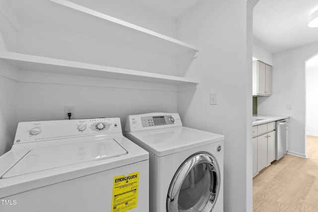 413 Top Greene Ln, Raleigh, NC 27601 - laundry area featuring washer and dryer, light wood-style floors, arched walkways, and baseboards