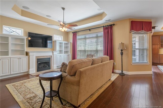 239 Nandina Ct Unit 21A, Fayetteville, NC 28311 - living room with a raised ceiling, a glass covered fireplace, baseboards, and a ceiling fan