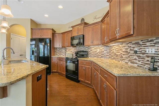 239 Nandina Ct Unit 21A, Fayetteville, NC 28311 - kitchen featuring black appliances, a sink, brown cabinets, dark wood-style flooring, and light stone counters