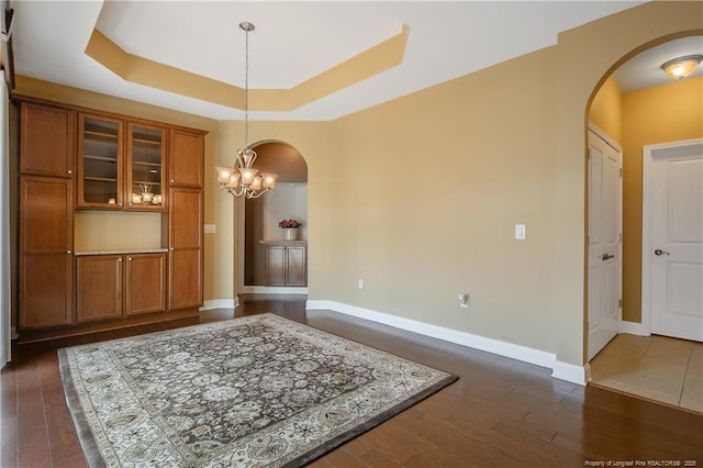 239 Nandina Ct Unit 21A, Fayetteville, NC 28311 - dining space with arched walkways, dark wood-type flooring, a chandelier, and baseboards