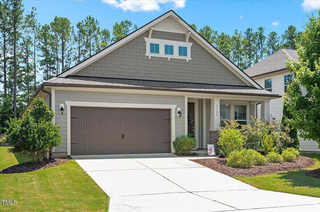 1724 Capstone Dr, Durham, NC 27713 - craftsman inspired home featuring concrete driveway, a garage, covered porch, and a front lawn