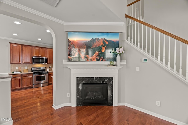 7873 Cape Charles Dr, Raleigh, NC 27617 - living area with recessed lighting, dark wood-style floors, stairs, a high end fireplace, and crown molding
