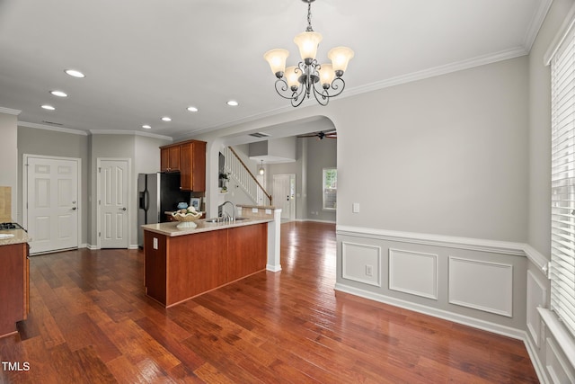 7873 Cape Charles Dr, Raleigh, NC 27617 - kitchen with arched walkways, recessed lighting, ornamental molding, brown cabinets, and a chandelier
