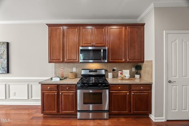 7873 Cape Charles Dr, Raleigh, NC 27617 - kitchen with stainless steel appliances, crown molding, dark wood finished floors, light stone countertops, and tasteful backsplash