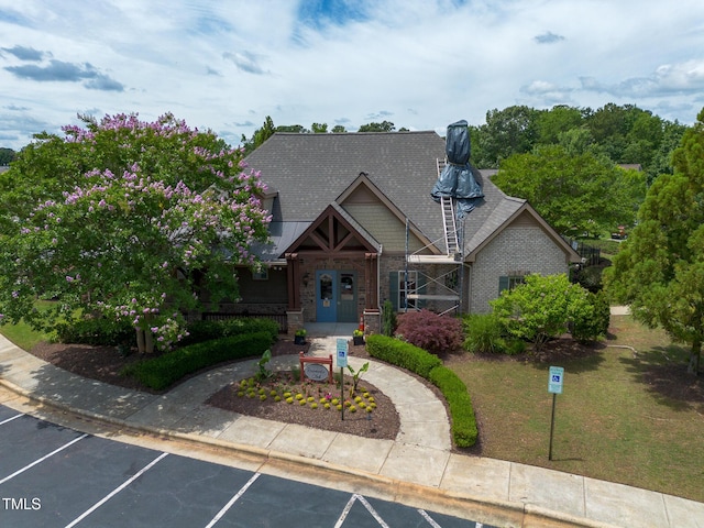 7873 Cape Charles Dr, Raleigh, NC 27617 - view of front facade with uncovered parking, a front yard, and brick siding