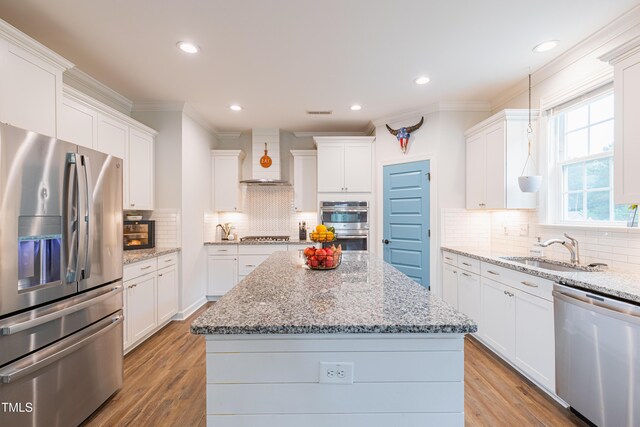 470 E Wellesley Dr, Clayton, NC 27520 - kitchen featuring stainless steel appliances, crown molding, tasteful backsplash, a kitchen island, and white cabinets