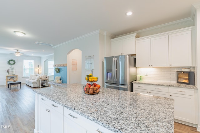 470 E Wellesley Dr, Clayton, NC 27520 - kitchen featuring stainless steel fridge with ice dispenser, arched walkways, crown molding, white cabinets, and recessed lighting