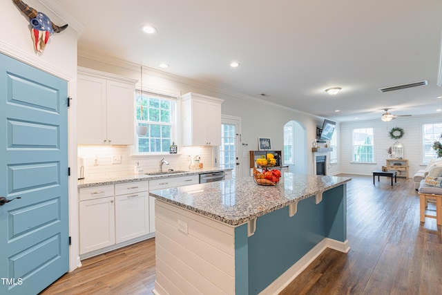 470 E Wellesley Dr, Clayton, NC 27520 - kitchen featuring open floor plan, arched walkways, a center island, dishwasher, and light wood-style flooring