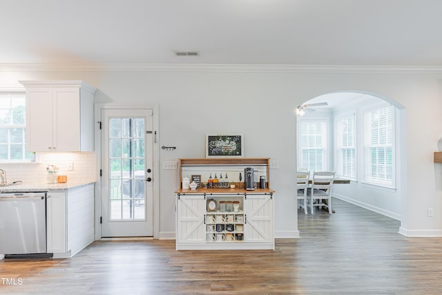 470 E Wellesley Dr, Clayton, NC 27520 - kitchen with stainless steel dishwasher, crown molding, light wood-style floors, white cabinetry, and plenty of natural light