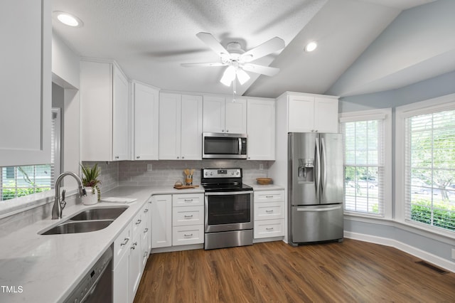115 Heatherwood Dr, Apex, NC 27502 - kitchen with stainless steel appliances, a sink, backsplash, white cabinetry, and dark wood-style flooring