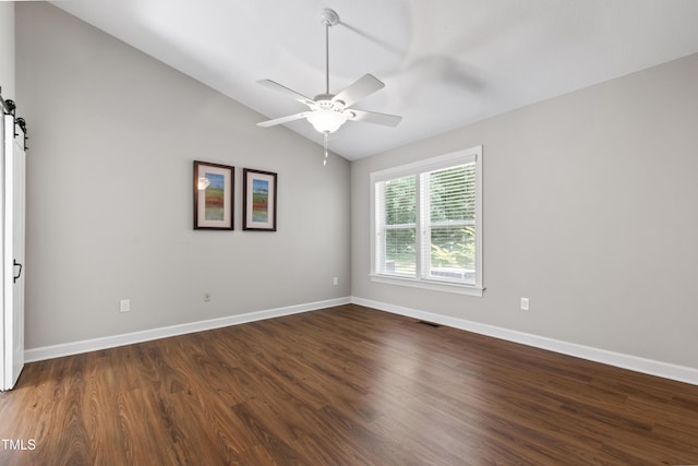 115 Heatherwood Dr, Apex, NC 27502 - spare room featuring a barn door, dark wood-type flooring, vaulted ceiling, ceiling fan, and baseboards