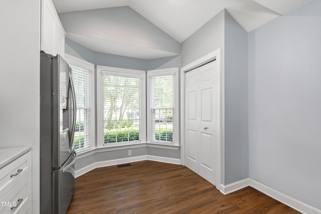 115 Heatherwood Dr, Apex, NC 27502 - unfurnished dining area featuring lofted ceiling, dark wood-style floors, and baseboards