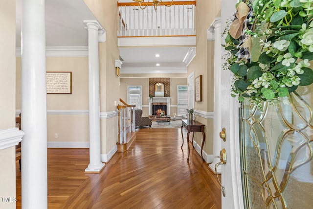 206 W Stoneybrook Ct, Benson, NC 27504 - foyer entrance with ornate columns, wood finished floors, crown molding, a brick fireplace, and baseboards