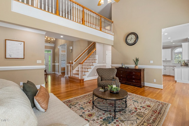 206 W Stoneybrook Ct, Benson, NC 27504 - living room with light wood-style floors, stairway, a high ceiling, baseboards, and recessed lighting